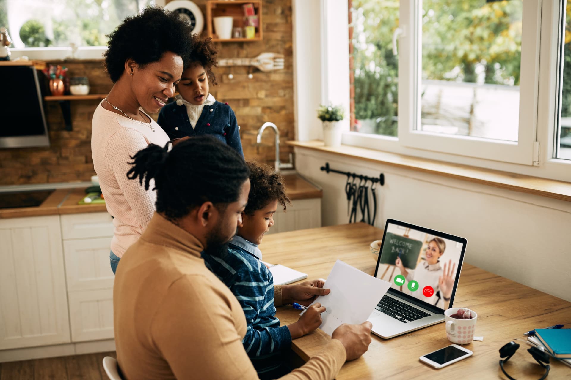 Família em videochamada na cozinha de casa