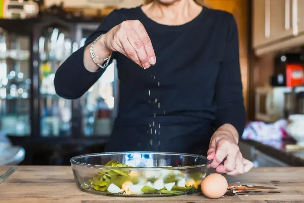 Mulher tempera a salada e alerta para os riscos do excesso de sal.