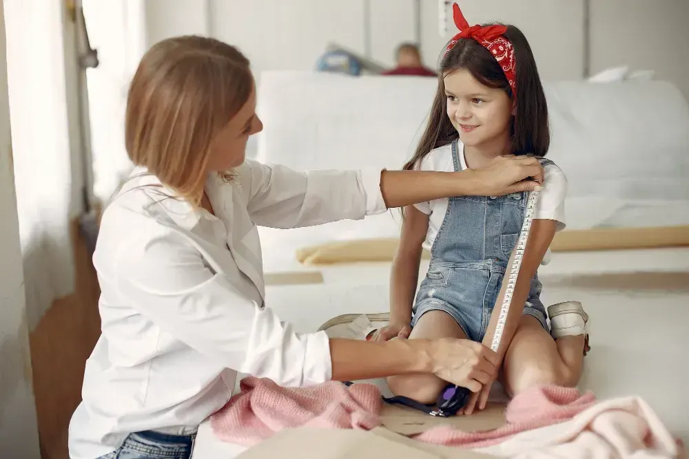 Médica verifica o tamanho de uma jovem menina e se ela precisa usar o GH hormônio do crescimento.